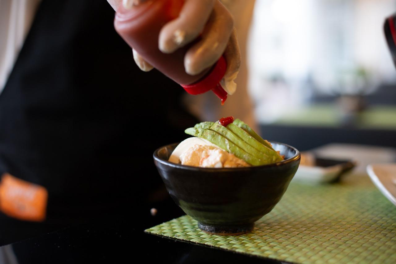 Chef preparing a dish with sauce at Jinambou
